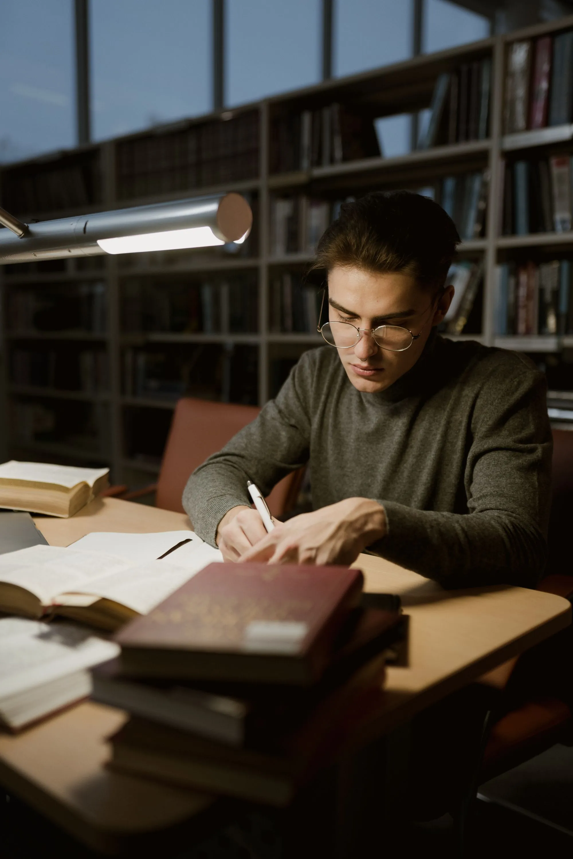 A man writing notes by hand at a desk