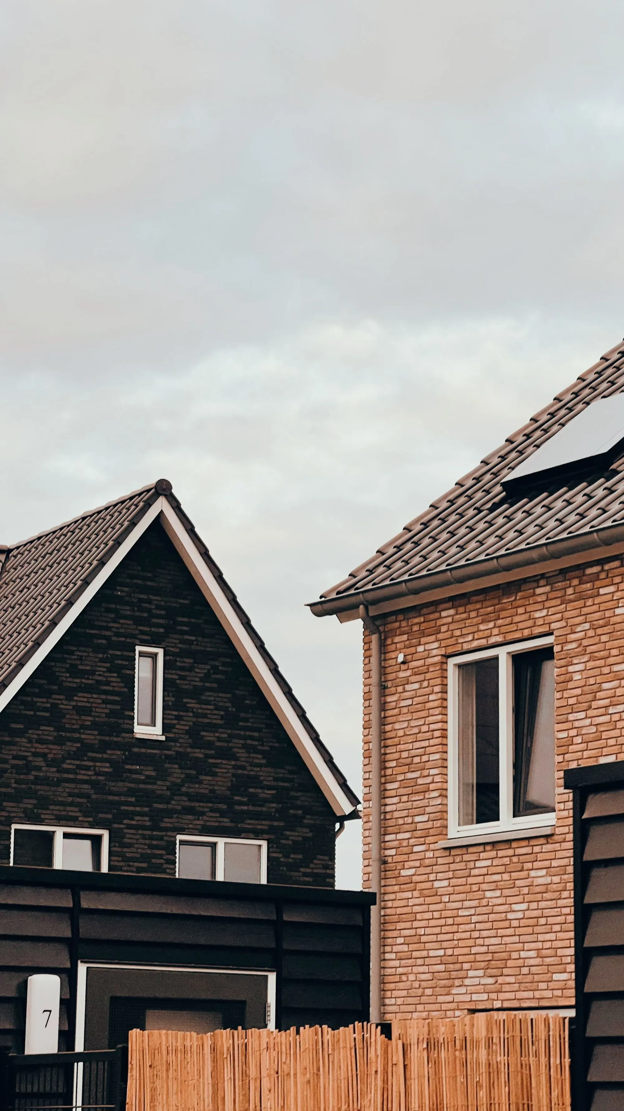 A brick house with steep shingled gables